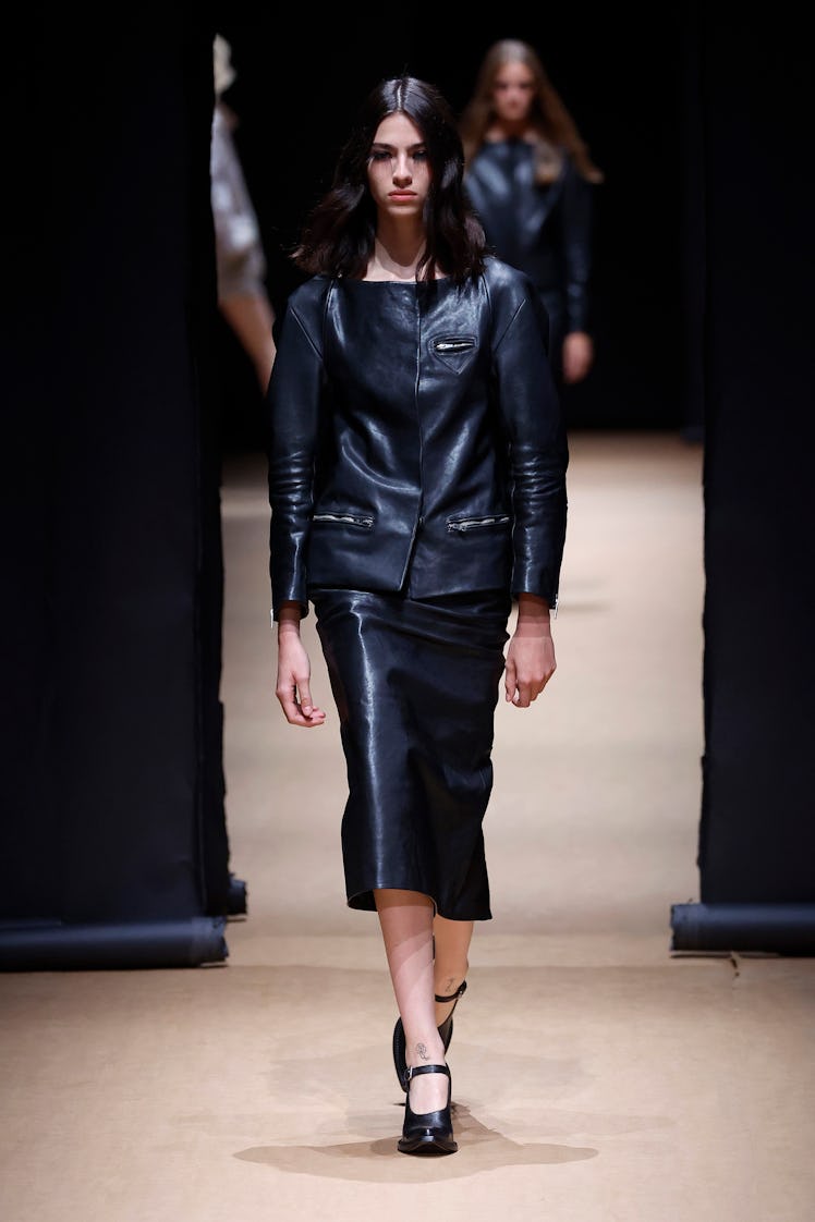 A model wearing a black leather suit from Prada's Womenswear Spring/Summer 2023