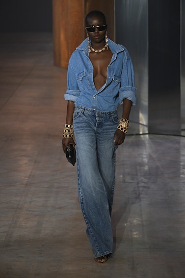 A model walking the runway in an all-denim outfit from Bally Ready to Wear Spring/Summer 2023 collec...