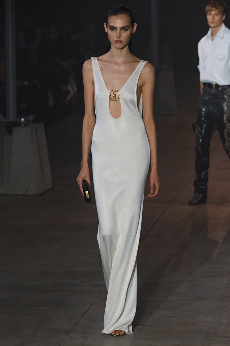 A model walking the runway in a white cut-out dress from Bally Ready to Wear Spring/Summer 2023 coll...