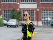 MILAN, ITALY - SEPTEMBER 24: Nina Sandbech wears black off shoulder top, black pants, neon green Bal...