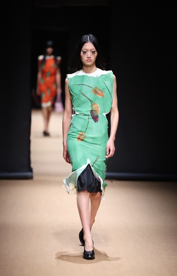 Prada's Spring/Summer 2023 mint green dress with a lacy slip skirt peeking out from under it.  