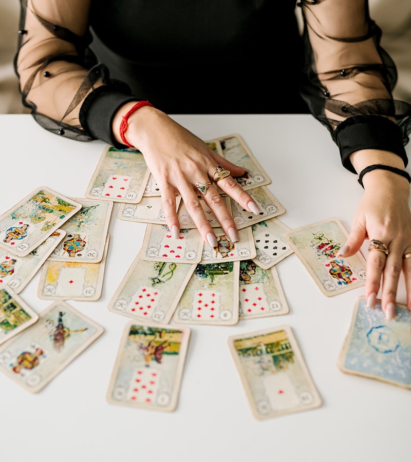 A tarot expert is shuffling her deck of cards.