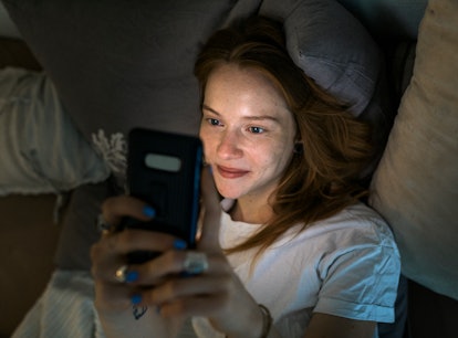 Gen Z woman sending her partner a sexy text message before bed.