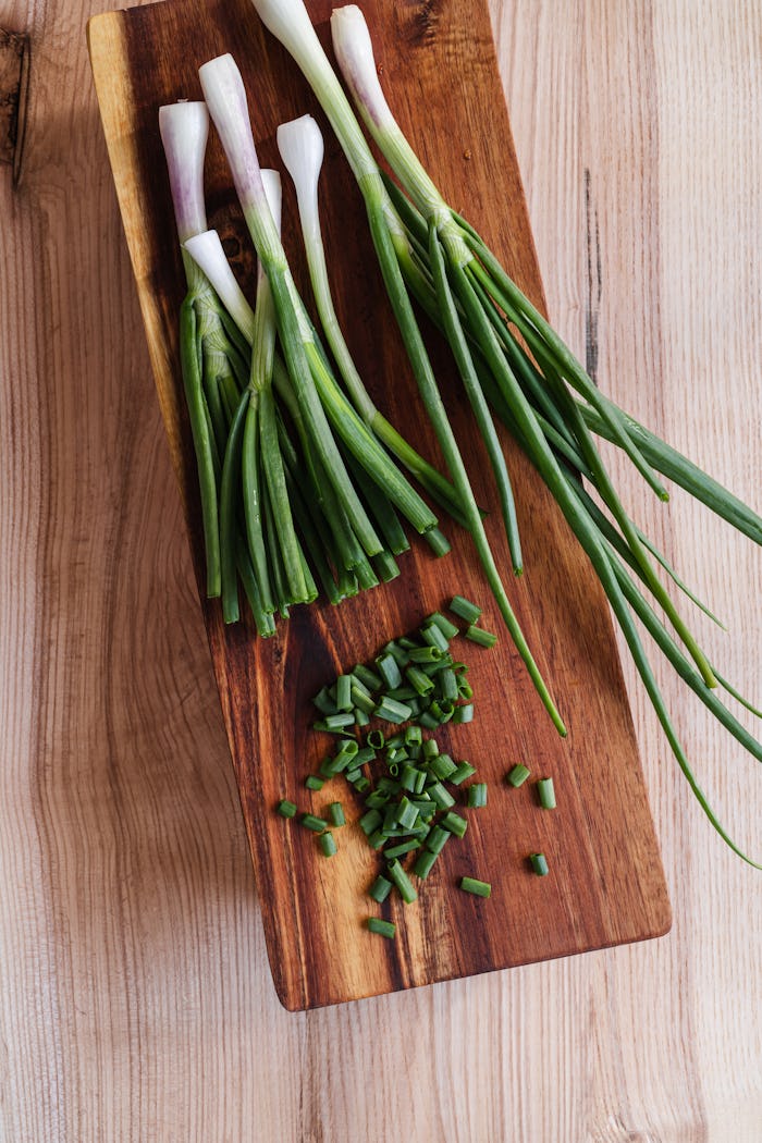 Growing fall vegetables at home means fresh scallions on demand, like these scallions being diced on...