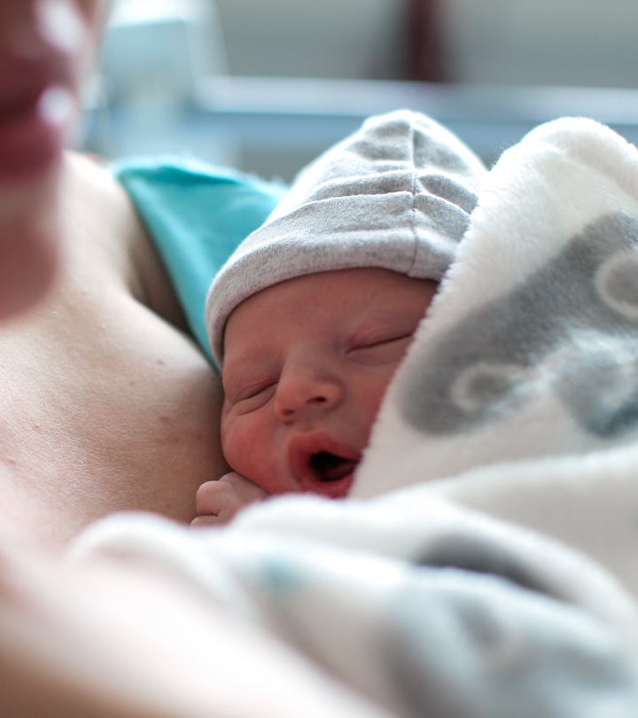 a Newborn baby boy breastfeeding for the first time in hospital, directly after a caesarean section