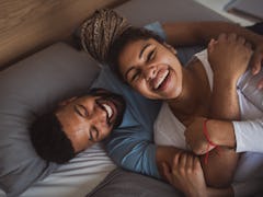 Man and woman resting in bedroom, having fun.