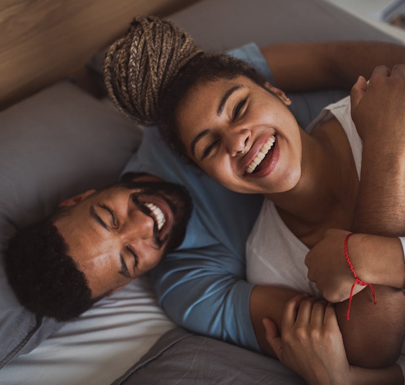 Man and woman resting in bedroom, having fun.