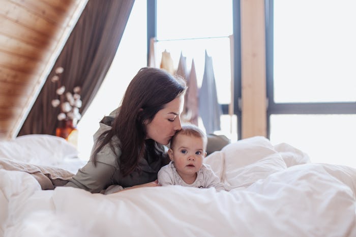 Young mother with little children enjoying morning and having fun together at cottage.