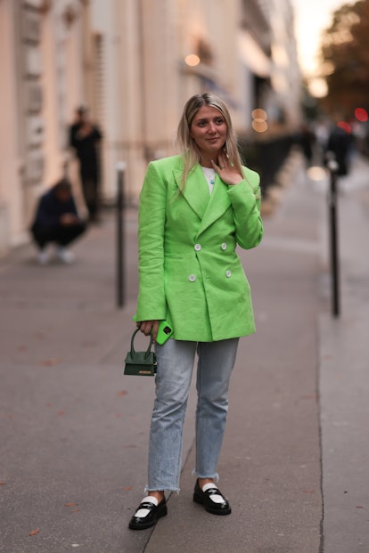 A fashion week guest seen wearing a Jacquemus green neon blazer and bag, outside Jacquemus.