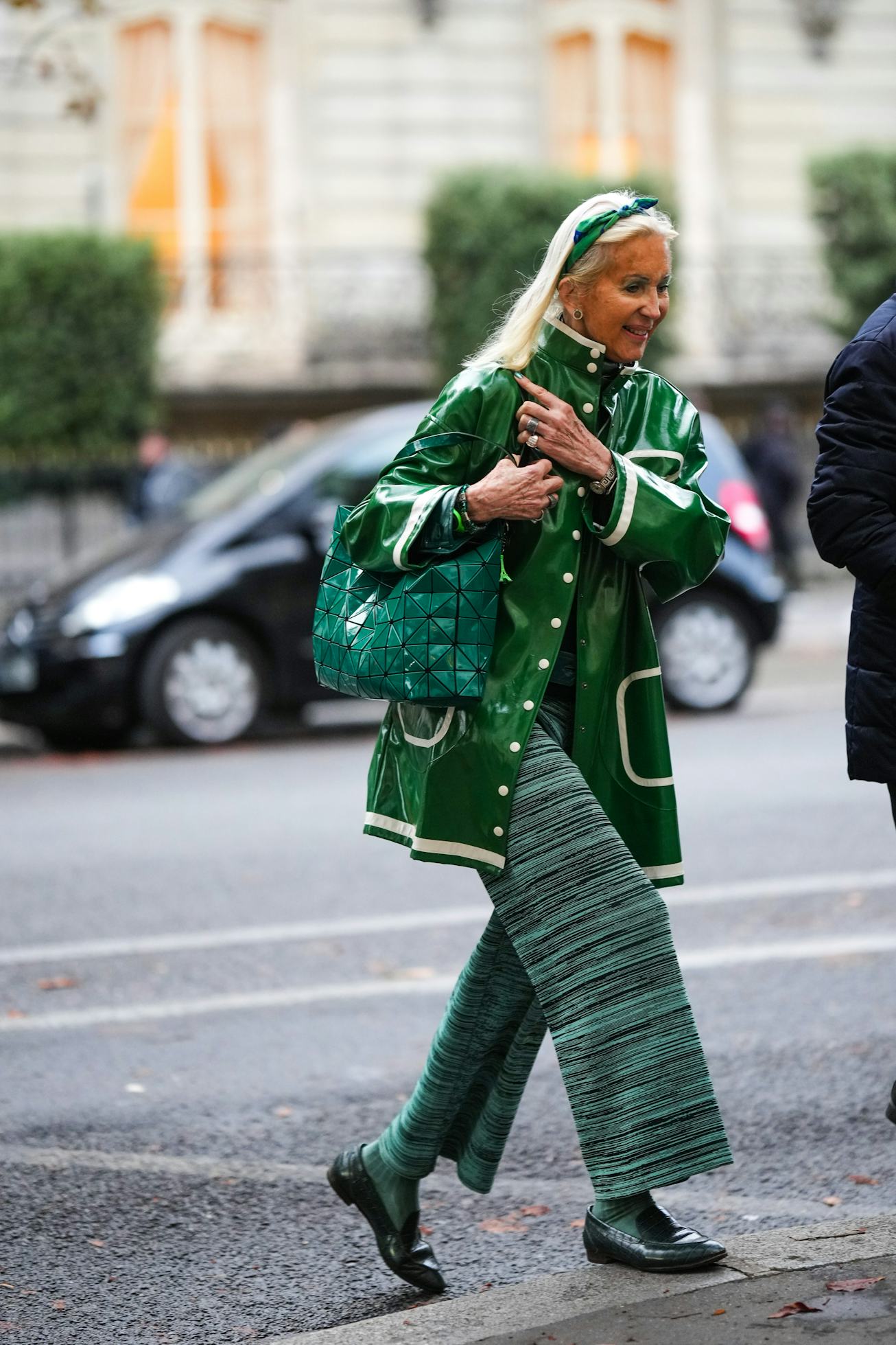 PARIS, FRANCE - SEPTEMBER 26: A guest wears a green and blue print pattern silk scarf as a headband,...