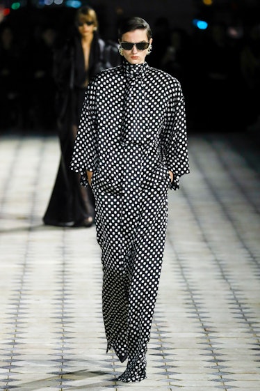 A model wearing Saint Laurent’s maxi polka black & white turtle-necked jumpsuit at the Paris Fashion...