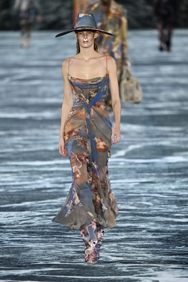A model wearing a Balmain flower dress, pants, and hat at Paris Fashion Week 2023.
