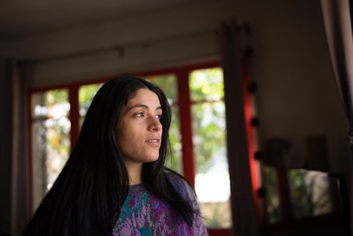 Contemplative mid adult woman looking through the view at home
