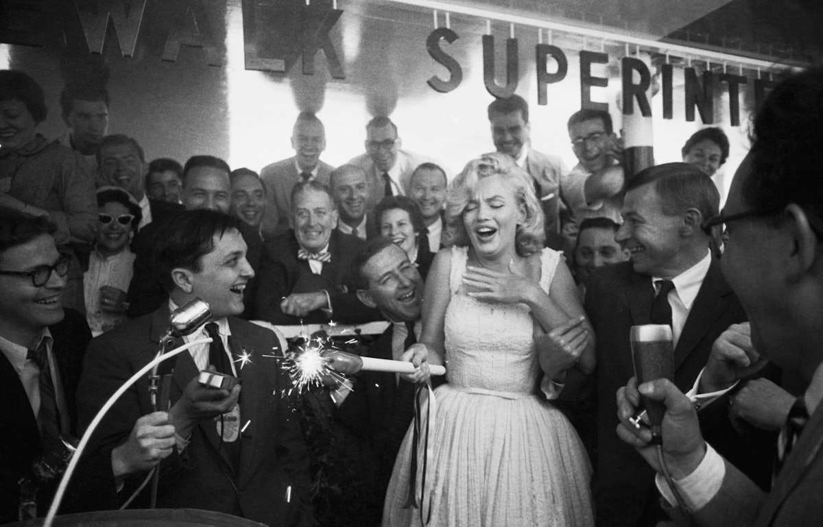 (Original Caption) As spectators look on mirthfully actress Marilyn Monroe registers shocked surpris...