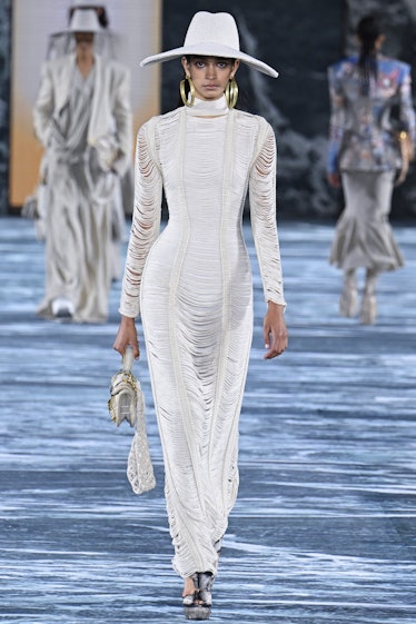 A model in Balmain’s white maxi skin-tight dress and white hat at Paris Fashion Week 2023
