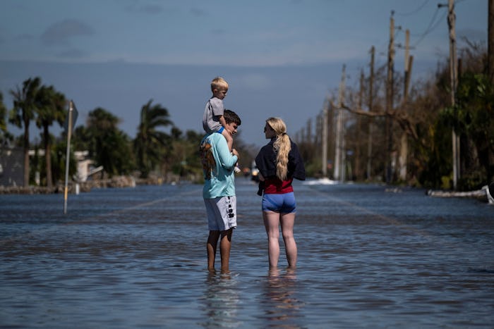 A family stand on a flooded street in the aftermath of Hurricane Ian.
