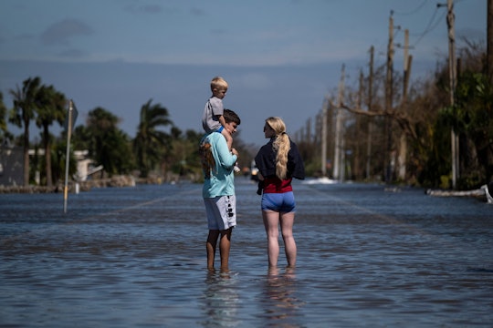 A family stand on a flooded street in the aftermath of Hurricane Ian.