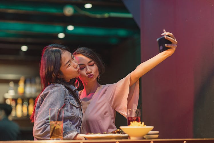 Two friends taking a selfie to symbolize the fifth house in astrology, which shows how you approach ...