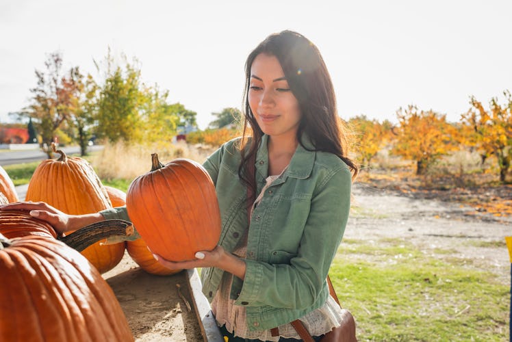 A woman shopping for pumpkins uses October quotes for Instagram captions.