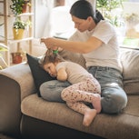 A mom checks her daughter for head lice. New guidance from the AAP states that kids with lice should...