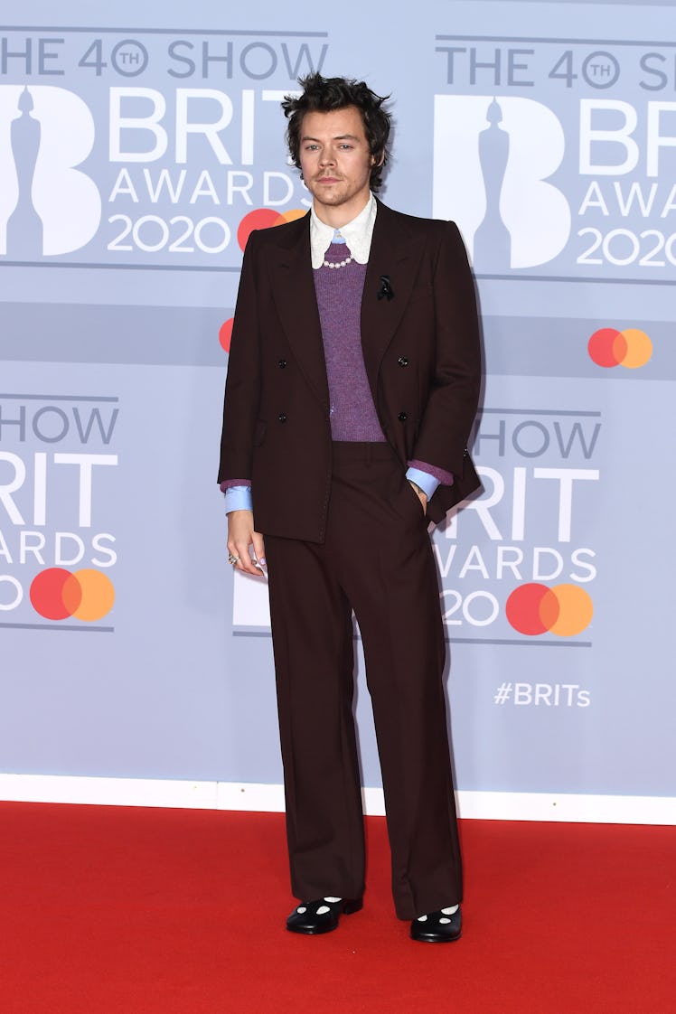Harry Styles Style Evolution: Styles wore a suit, purple sweater, and pearl necklace to The BRIT Awa...