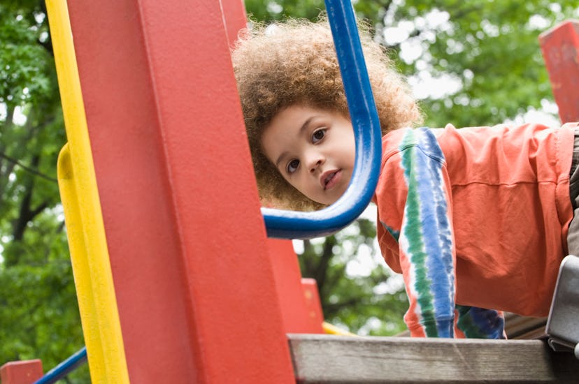 Child playing and thriving using the slide in the playground. 