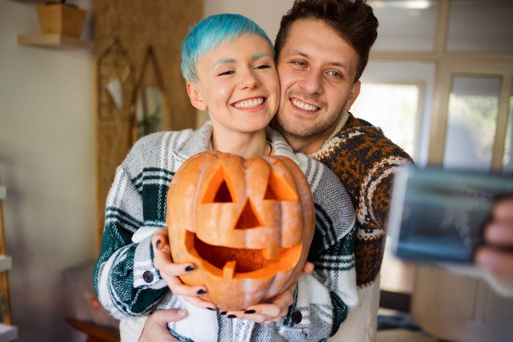 Couple taking a selfie on Halloween to post on Instagram.