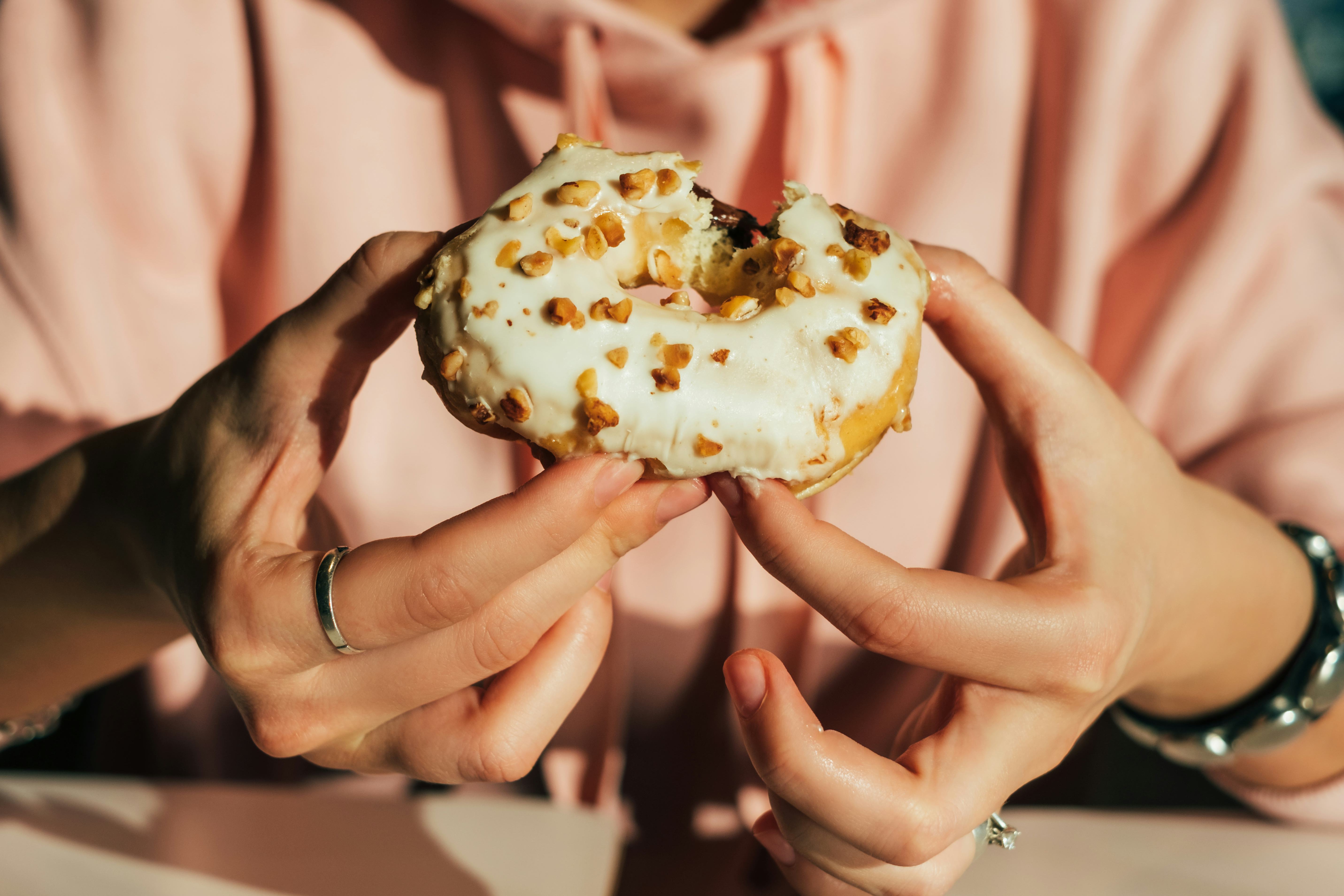 A mouthwatering fall donut with a white glaze and nuts