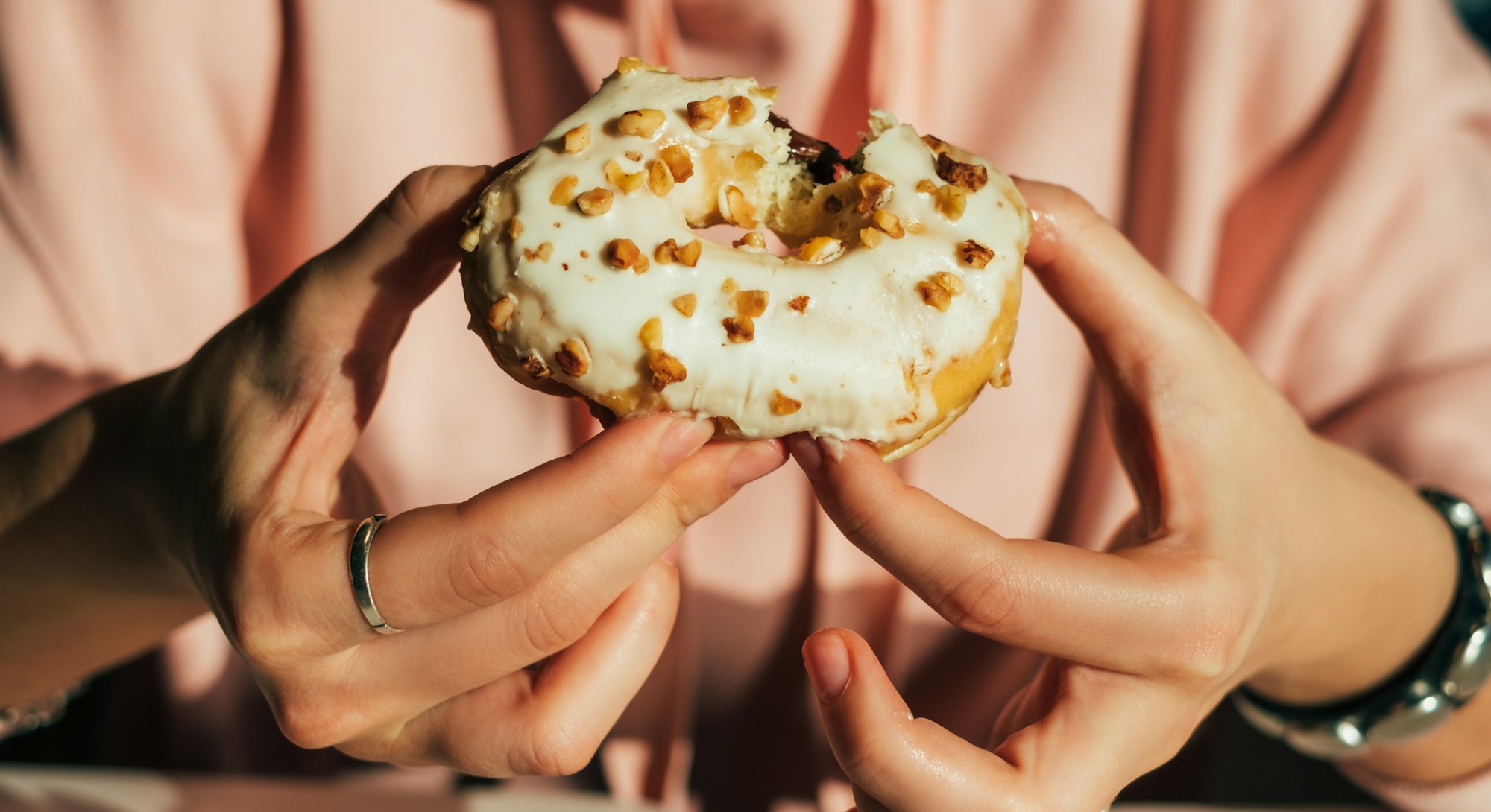 A mouthwatering fall donut with a white glaze and nuts