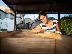 Woman varnishing and painting the renovated furniture of her house