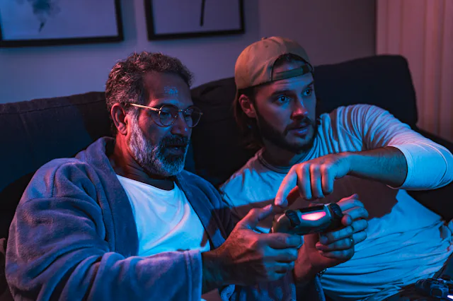 Special Family Moments - Close up of father and son enjoying evening at home and playing video games...