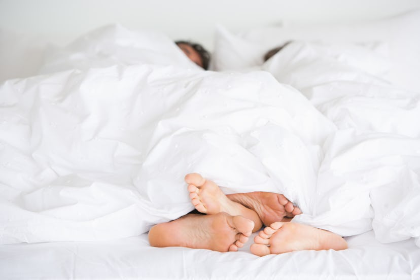 couple in bed together in an article about why some people bleed after sex