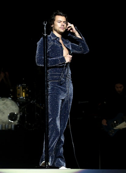 Harry Styles' Style Evolution: a sequined, faux denim jumpsuit performs on stage during day one of C...