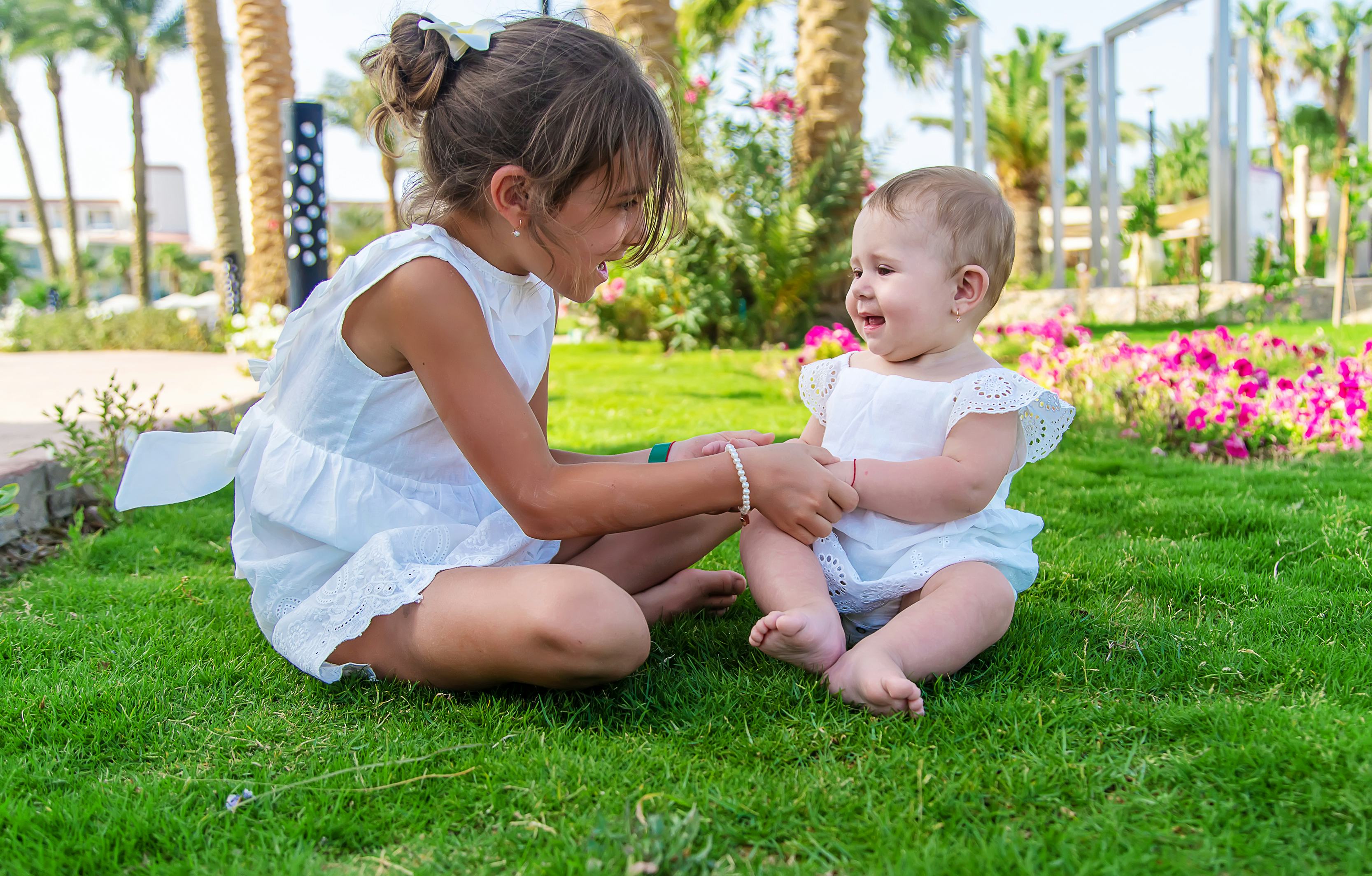 The girl's children are sitting under a palm tree. Selective focus. Nature.