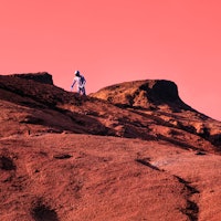 Astronaut walking on red Mars rock