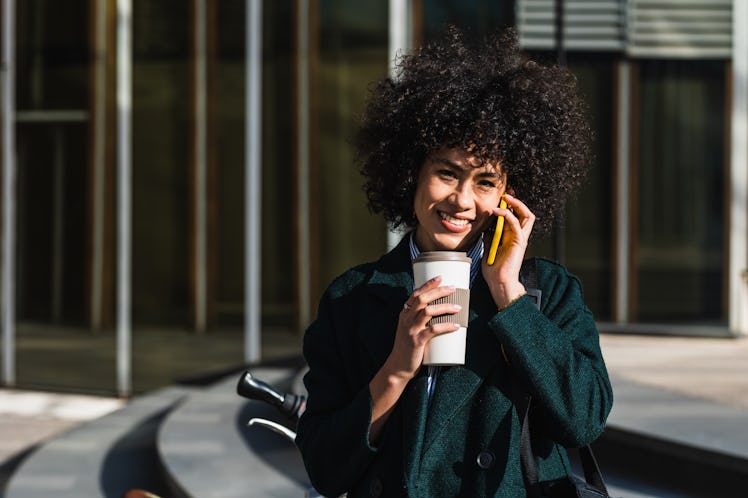 young woman smiles as she talks on the phone about her september 12, 2022 weekly horoscope 