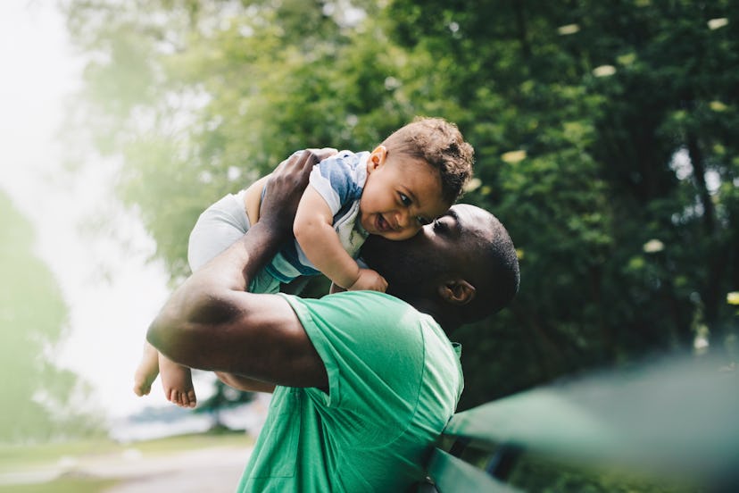 dad snuggling his baby boy in an article about boy names that start with C