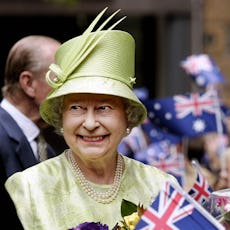 Britain's Queen Elizabeth II smiles after she received flowers from waiting school children followin...