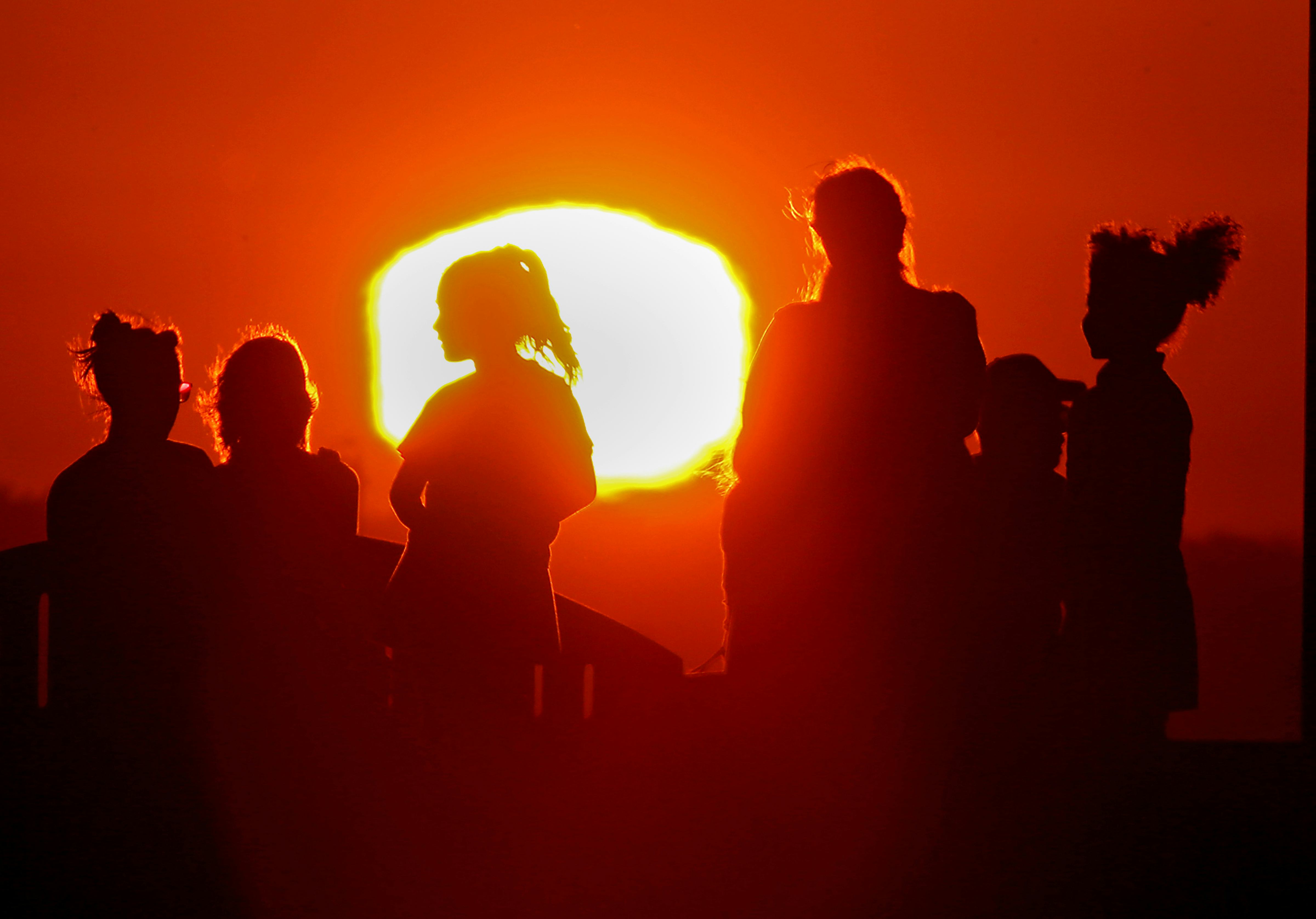 LONG BEACH, CALIF. - SEPT. 1, 2022. The blazing sun silhouettes visitors to Signal Hill after anothe...
