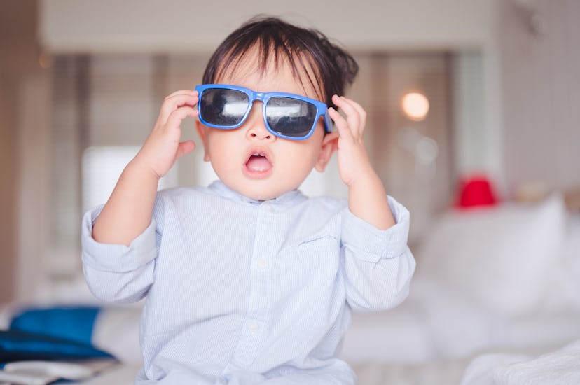 a cute boy playing with sunglasses in an article about boy names that start with C