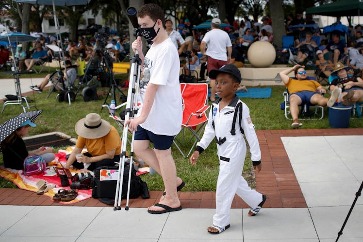 A child wearing an astronaut costume leaves after the launch of the Artemis I unmanned lunar rocket ...