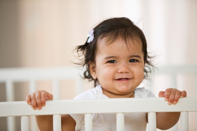 a cute baby girl in a crib in an article about girl names that start with C