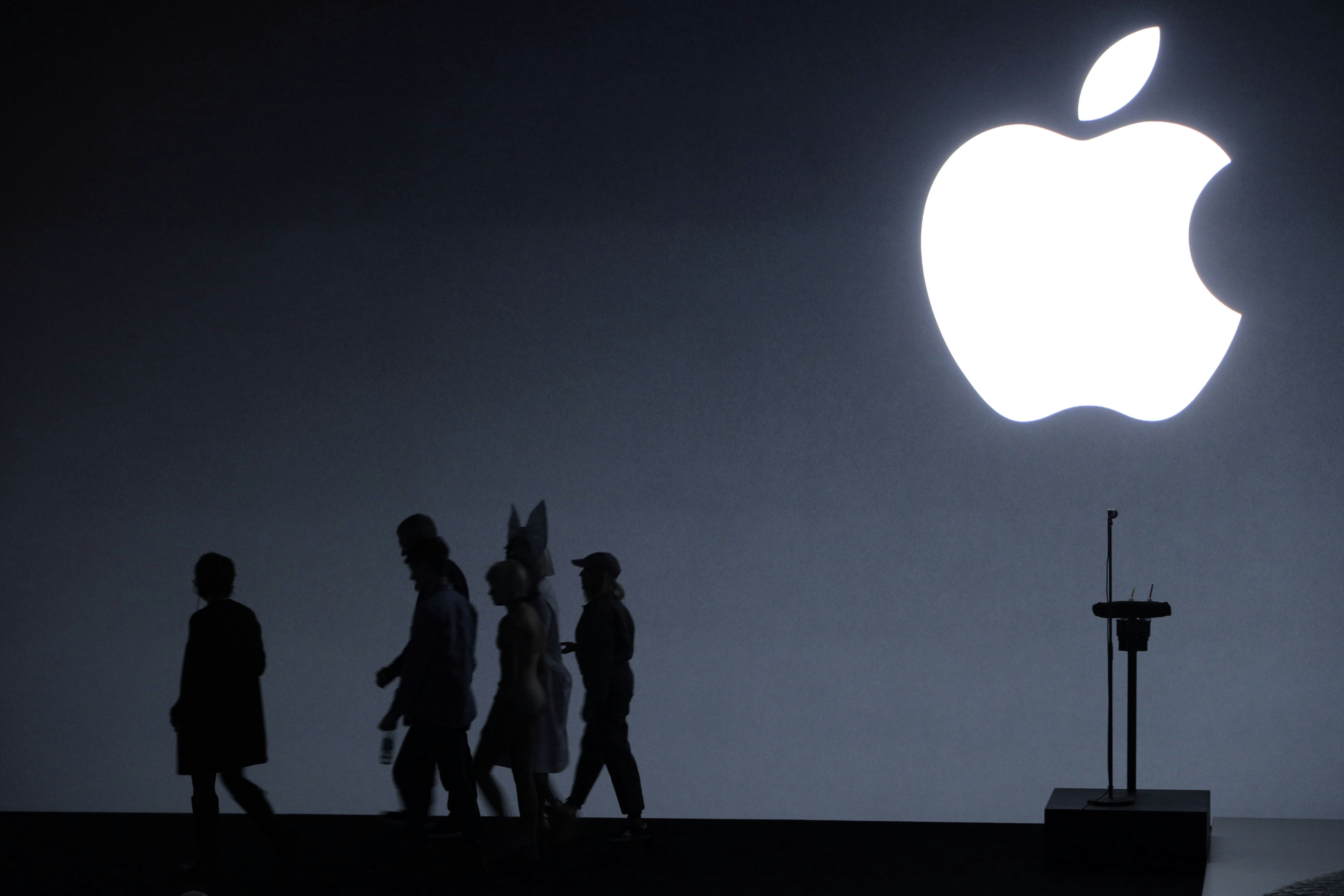 Apple CEO Tim Cook, singer Sia, and dancer Maddie Ziegler leave the stage following an Apple Event t...