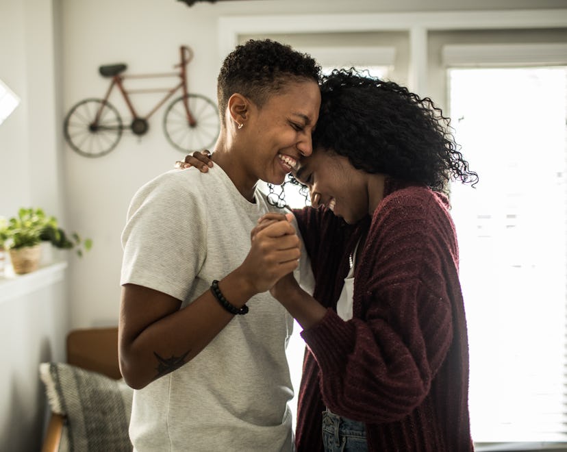 Lesbian couple dancing in living room, playing fun valentine's day for couples