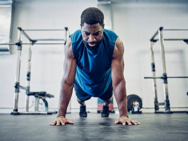 A man doing a plank at a gym.