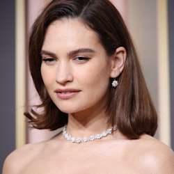  Lily James attends the 80th Annual Golden Globe Awards wearing a side-parted bob and soft neutral m...