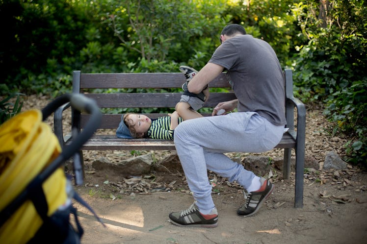 Dad is using a bench to change the nappie of his son
