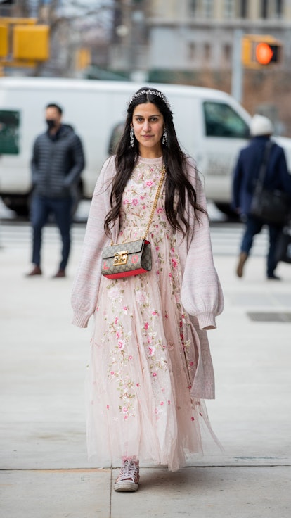 A runway show guest wearing a floral spring dress in winter.