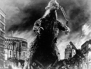 Radioactive monster Godzilla stomps through a city and eats a commuter train in a scene from 'Godzil...