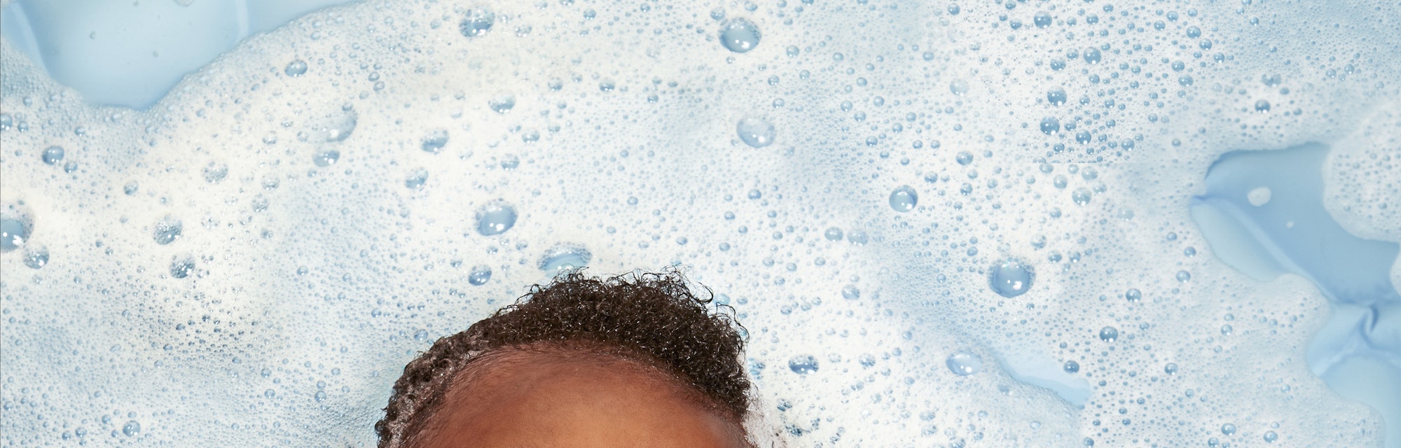 happy baby playing in bubble bath for article on aquarius names for baby boys